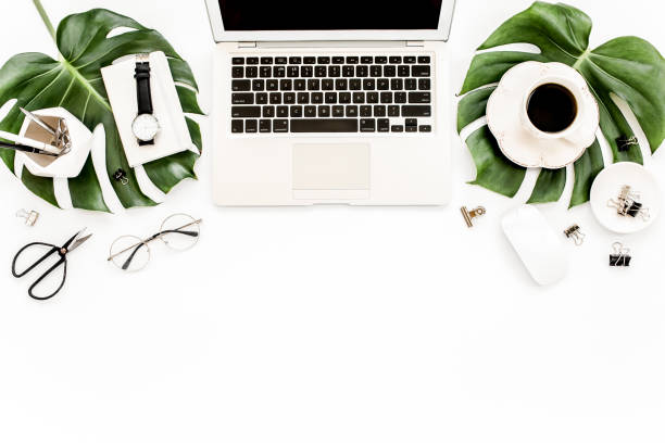 istock Home office workspace mockup with laptop, tropical leaves Monstera, clipboard, notebook and accessories on white background. Flat lay, top view 1270633311
