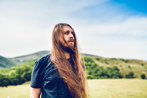 Wind Blowing Long Male's Hair During Hiking In Mountains