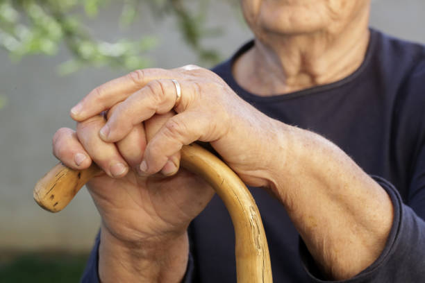 istock Elderly womans hands holding wooden walking stick 1270634002