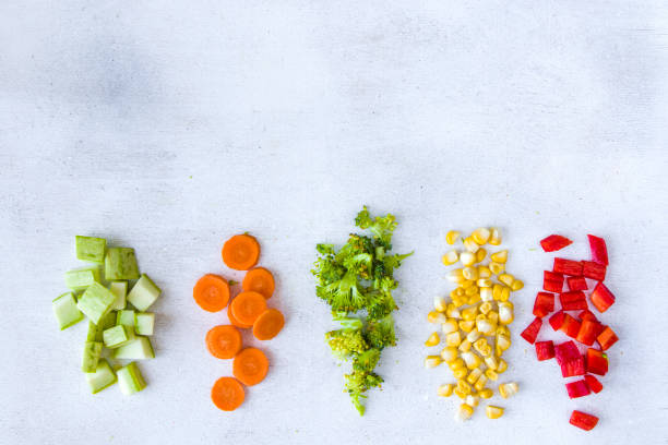 istock Chopped vegetables on the white background, carrot, broccoli, corn and bell pepper 1270634132