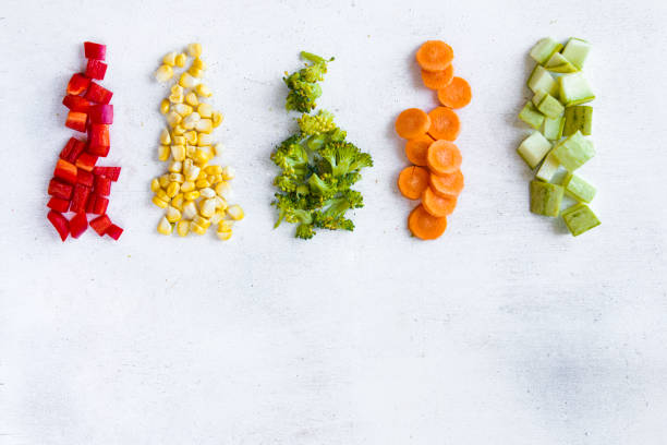 istock Chopped vegetables on the white background, carrot, broccoli, corn and bell pepper 1270634274