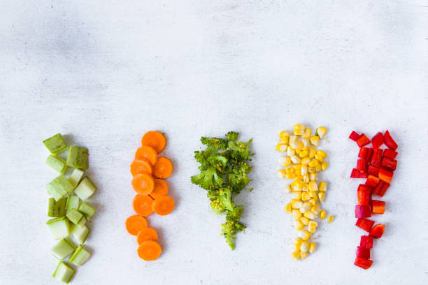 istock Chopped vegetables on the white background, carrot, broccoli, corn and bell pepper 1270634347