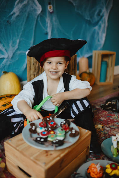 istock Cute little boy putting candy in small basket at home 1270636270