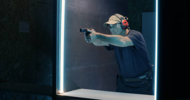 istock Mature shooter firing pistol in dark range 1270638165