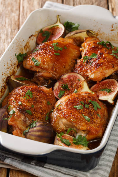 istock Spicy chicken thighs baked with fresh figs and herbs close-up in a baking dish. vertical 1270641343