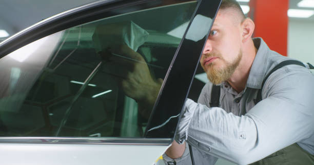 istock Bearded mechanic spraying tinted window 1270641666