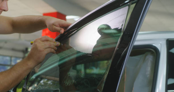 istock Bearded mechanic spraying tinted window 1270641687