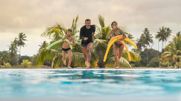 istock Father and children jumping in the pool 1270646792