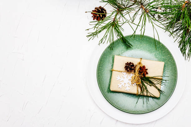 istock Christmas or New Year table setting. Festive cutlery, ceramic plates with fresh pine branch, cones, zero waste gifts and star anise 1270649056