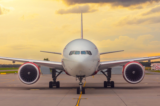 Front view exactly of a wide-body aircraft sunset at the airport