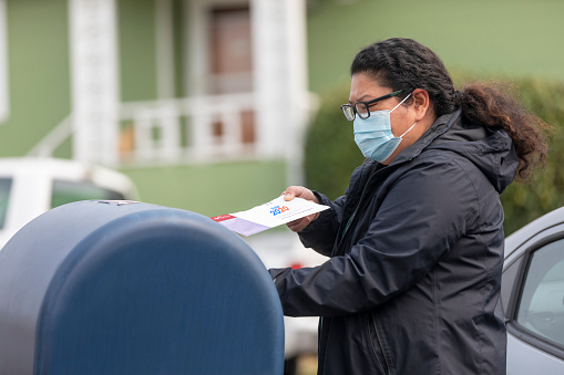 High quality stock photo of a senior Asian American woman voting by mail in California.