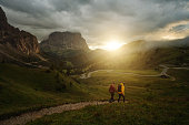 Man and woman photographers hiking in mountain of Dolomites in the fog