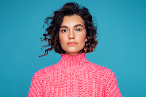 Beautiful woman in pink sweater with curly hair