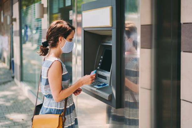 istock Woman using credit card at the ATM 1270654803