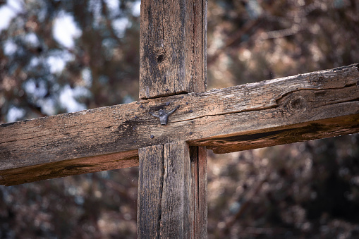 Old, destroyed and neglected Catholic roadside cross. On a broken cross a figure of Jesus Christ in half.