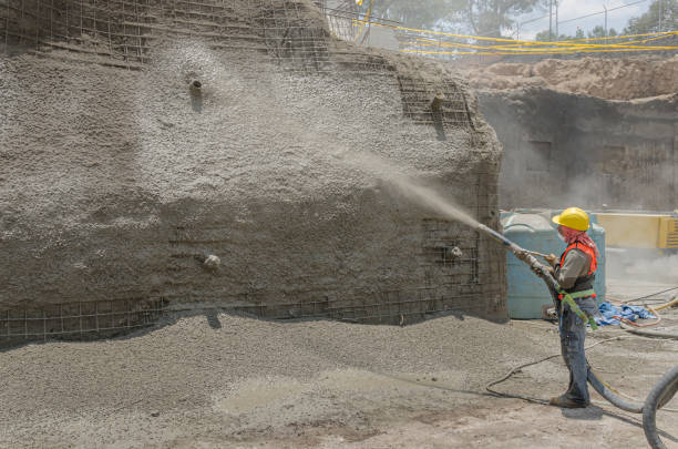 Concrete pumping hose used to cover with cement a construction wall Cement applied with high pressure to create masonry walls grill rods stock pictures, royalty-free photos & images