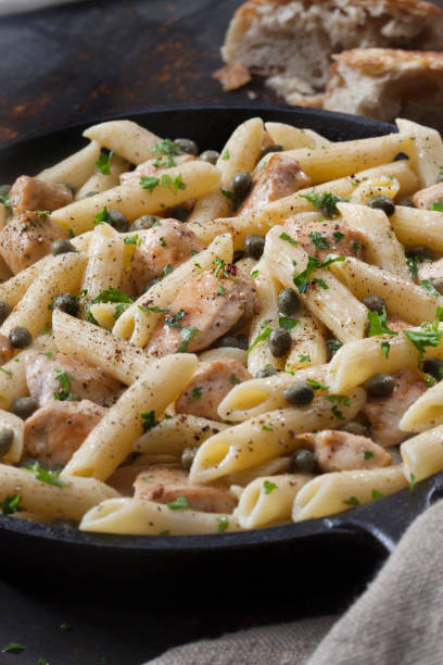 Grilled Chicken Piccata with Penne Pasta and Fresh Artisan Bread Grilled Chicken Piccata with Penne Pasta and Fresh Artisan Bread chicken rigatoni stock pictures, royalty-free photos & images