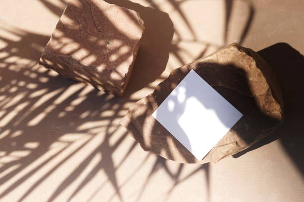 istock Blank paper sheet cards template, stone and sunlight palm shadows on beige textured background. Flat lay, top view.copy space. Business podium mock up . 1270660793