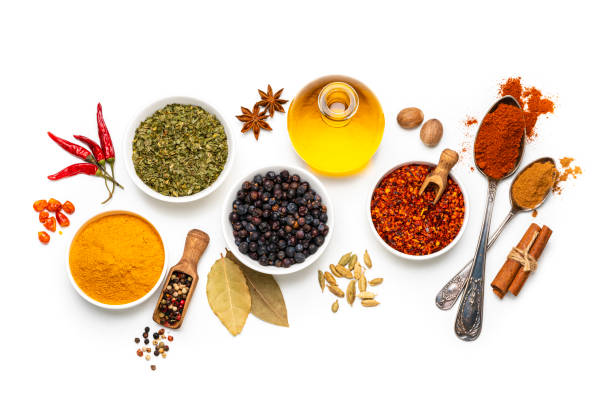Spices variation on white background. Overhead view Cooking backgrounds: overhead view of several bowls and spoons with multicolored spices shot on white background. The composition includes dried oregano, turmeric, peppercorns, chili pepper cinnamon, bay leaves, cardamom, nutmeg and olive oil. High resolution 42Mp studio digital capture taken with Sony A7rII and Sony FE 90mm f2.8 macro G OSS lens condiment photos stock pictures, royalty-free photos & images