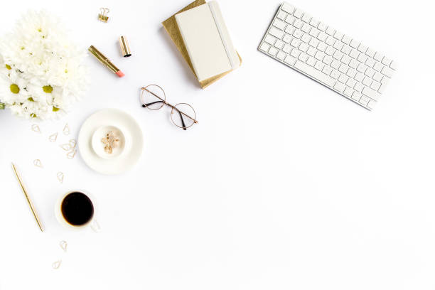 Women's stylish table desk. Workspace with computer, coffee and feminine accessories on white background. Magazines, websites. Flat lay, top view