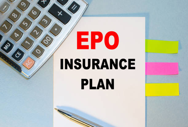 istock EPO INSURANCE PLAN is written on a notepad next to multicolored stickers, a calculator and a pen on a blue background. Business concept 1270667624