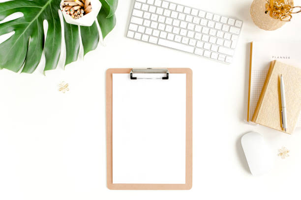 istock Flat lay home office desk. Female workspace with computer, clipboard, tropical palm leaves Monstera, accessories on white background. Top view 1270668579