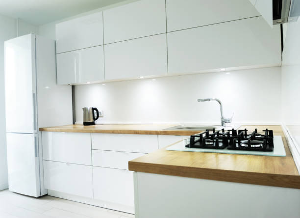 istock White luxury kitchen view with tools and flowers, modern kitchen tools with white walls, wash basin and gas cooker have attached to the wall, green flower vase on the table, perfect lightning. 1270670570