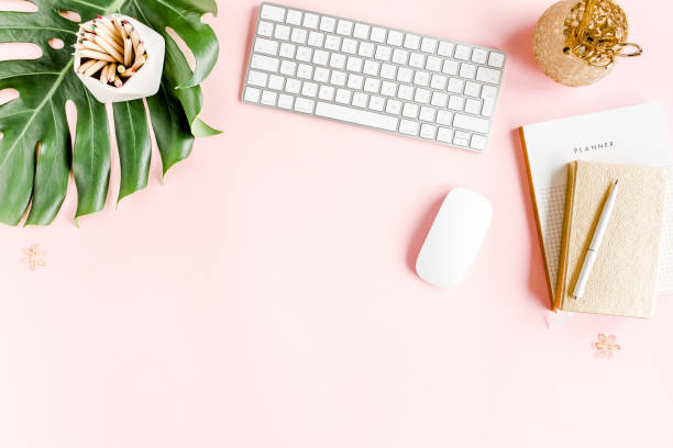 istock Flat lay home office desk. Female workspace with computer, tropical palm leaves Monstera, accessories on pink background. Top view background 1270671456