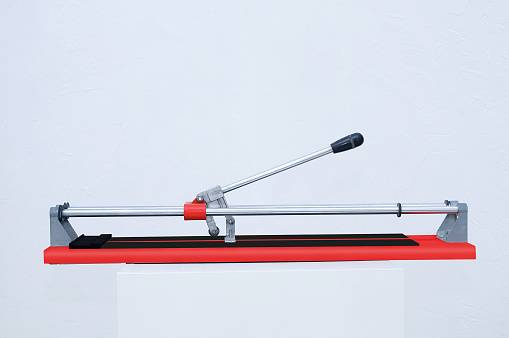 Red tile cutter. Construction tool. Repair and home improvement. White background.