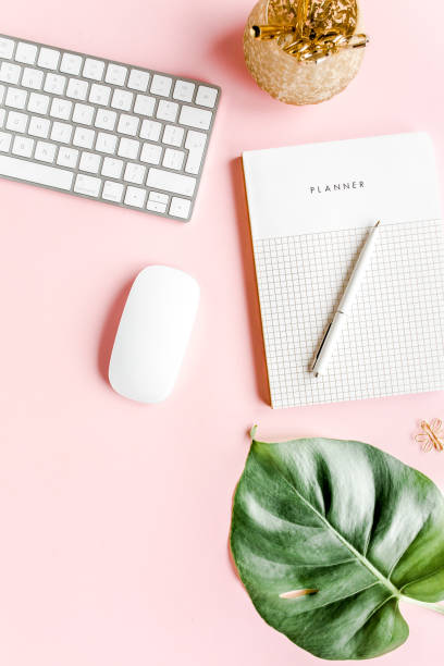 istock Flat lay home office desk. Female workspace with computer, tropical palm leaves Monstera, accessories on pink background. Top view background 1270671684