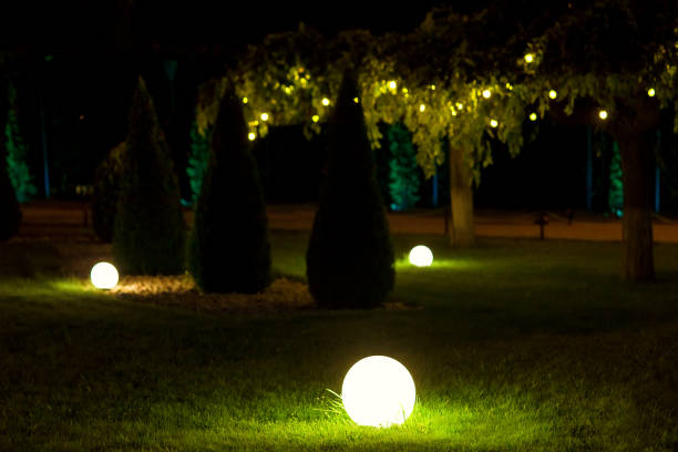 istock illumination backyard light garden with electric ground lantern with round diffuser near arborvitae and garland of light bulbs on tree branch with leaves, landscaping illuminate night scene, nobody. 1270672734