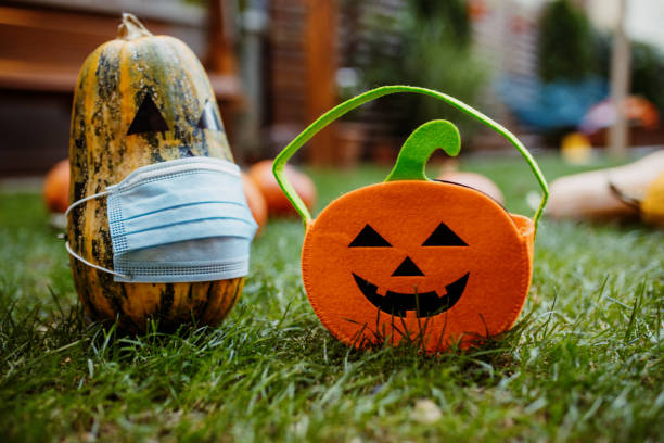 istock Pumpkins on the grass with face protective mask during Covid-19 pandemic 1270678884