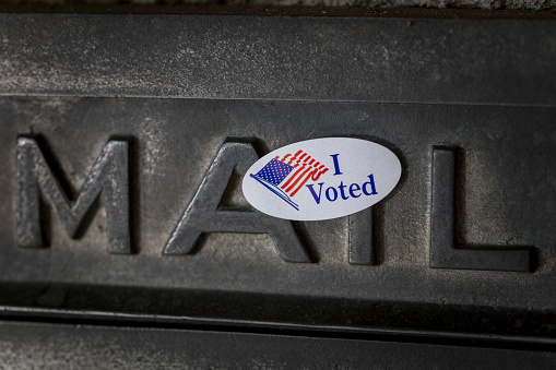 Photograph of I voted sticker on old fashioned mail slot.