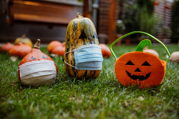 istock Pumpkins on the grass with face protective mask during Covid-19 pandemic 1270679625