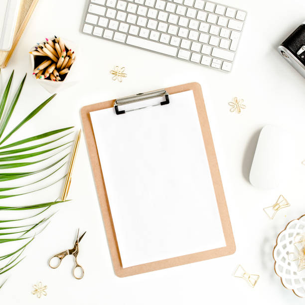 istock Flat lay home office desk. Female workspace with computer, clipboard, tropical palm leaves, accessories on white background. Top view 1270680943