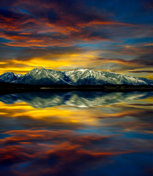 reflection of jackson lake: sunset over the majestic peaks of the teton range, grand teton national park in the u.s. state of wyoming - snake river teton range mountain range mountain imagens e fotografias de stock