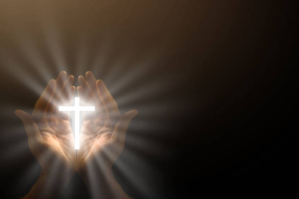 istock Man hands praying in dark background 1270682293