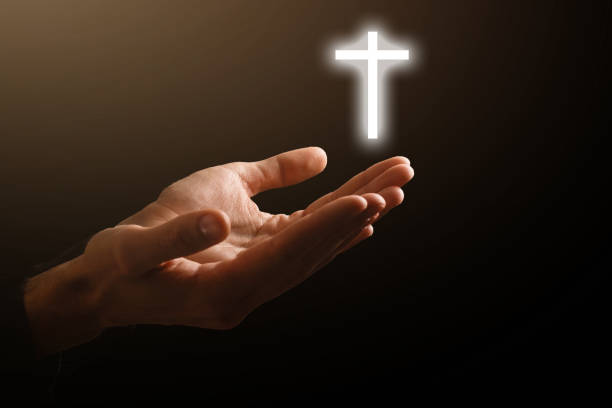istock Man hands praying in dark background 1270682311