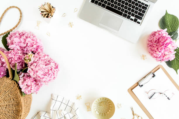 istock Workspace with clipboard, laptop, bouquet hydrangea, accessories on white background. Stylized women's desk. Flat lay. Top view 1270683138
