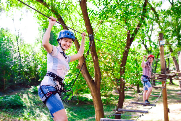 adventure climbing high wire park - people on course in mountain helmet and safety equipment stock photo