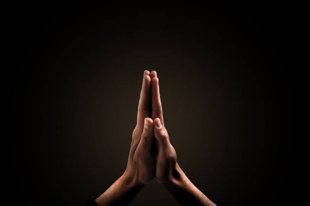 istock Hands clasped. Close-up of hands clasped isolated on black 1270683324