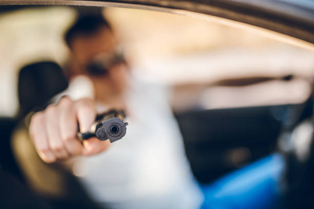 istock Man driving a car and holding a gun 1270683733