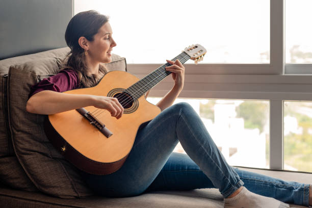 istock Happy woman playing guitar 1270683755