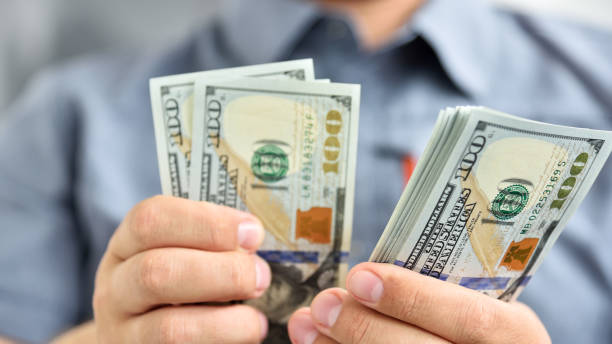 istock Businessman counting hundred dollar bills. 1270684644