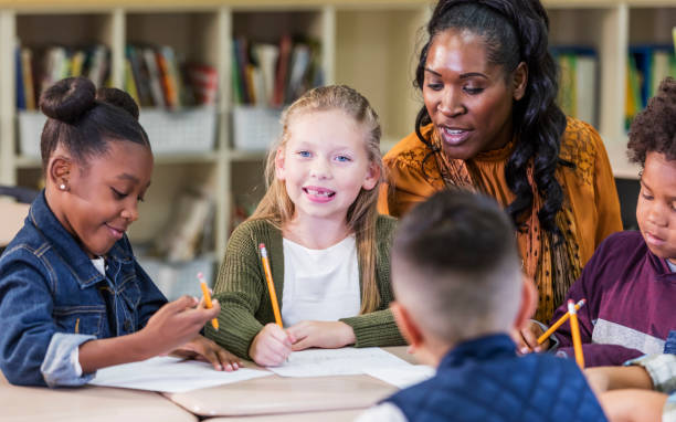 istock Girl with teacher and classmates in elementary school 1270685523