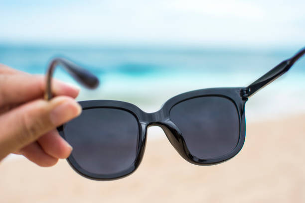 istock Hand wearing sunglasses on the beach 1270685578