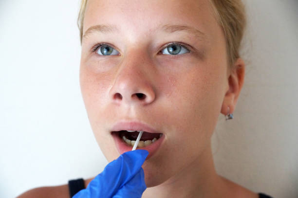 le médecin fait un test pour le coronavirus de la bouche de la jeune fille - pathogen streptococcus life science photos et images de collection
