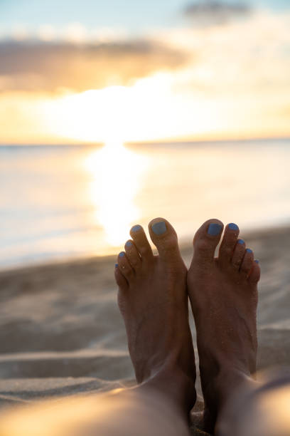 istock Feet in the sand and sunset over the ocean 1270688190