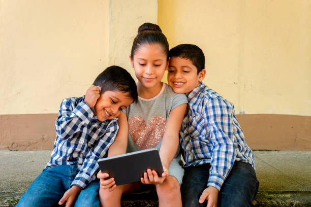 istock three child brothers on cell phone and tablet 1270689377