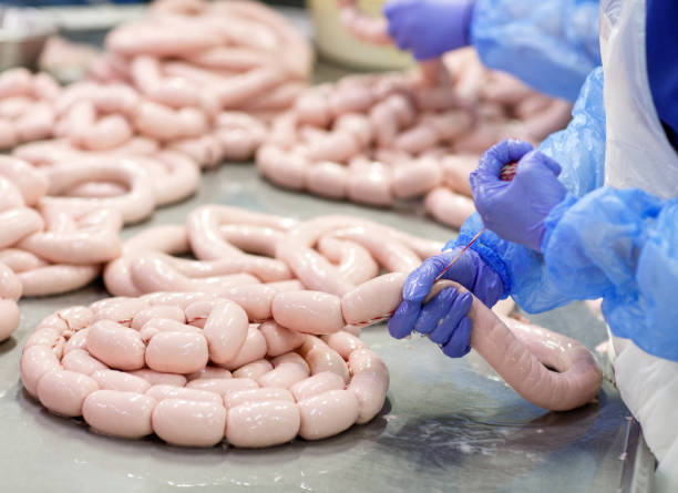 istock Butchers processing sausages at a meat factory. 1270691462